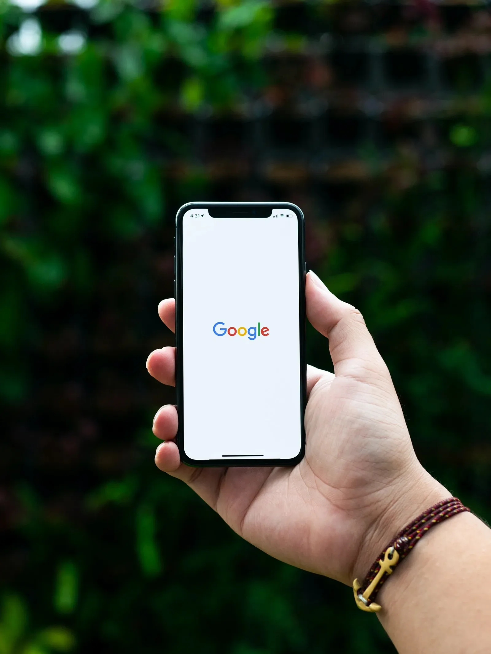 Hand holding a phone open to the Google search page