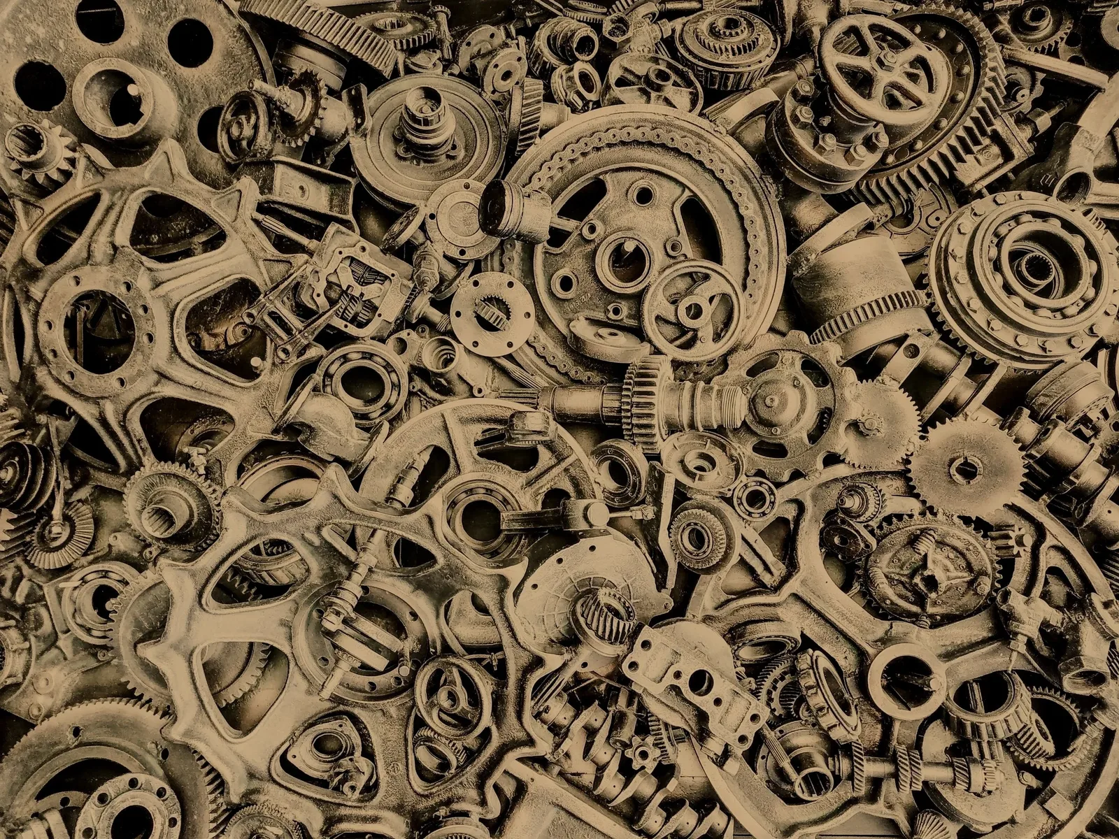 Pile of interlocking bronze gears and machine parts