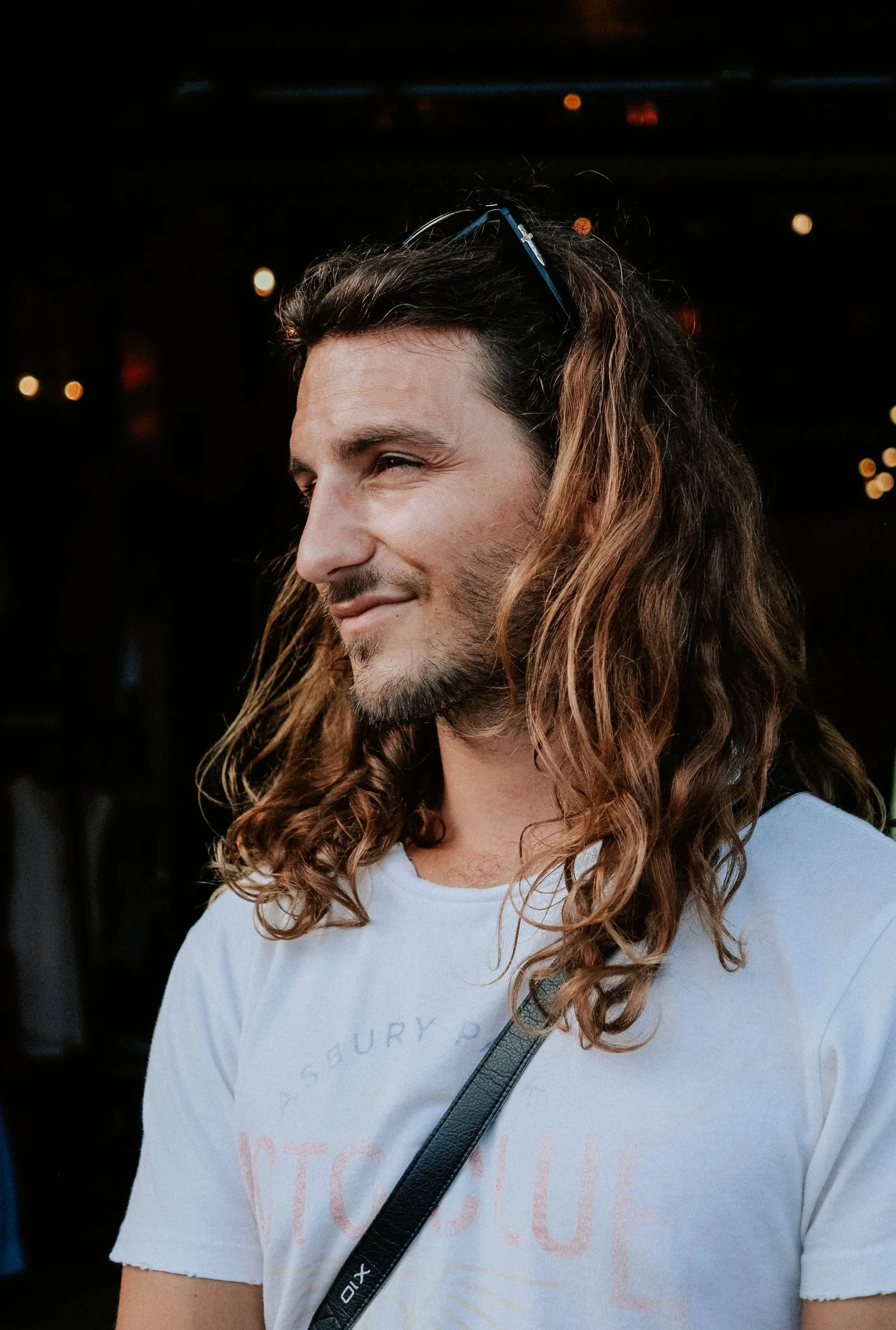 Mike Forgie in profile, smiling, with long curly hair